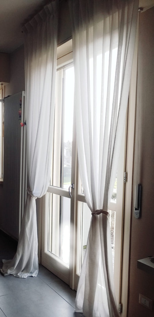 La Nautica white linen curtains tied back beside a glazed door