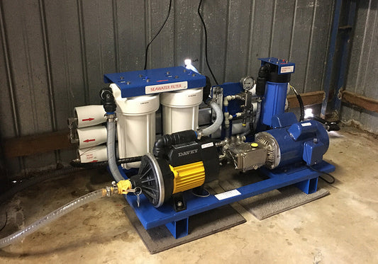 Skid-mounted marine reverse osmosis watermaker with twin seawater pre-filters, high-pressure pump and pressure gauge