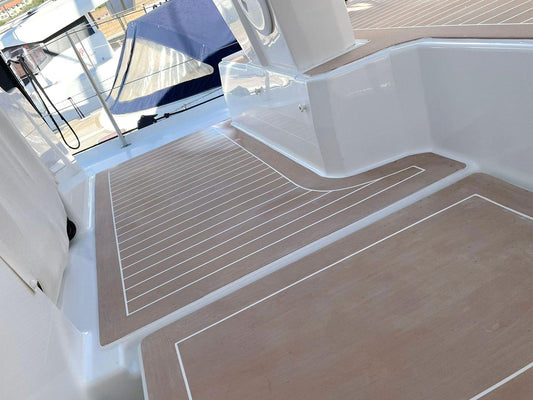 Seamless synthetic deck flooring with caulk lines installed in a yacht cockpit