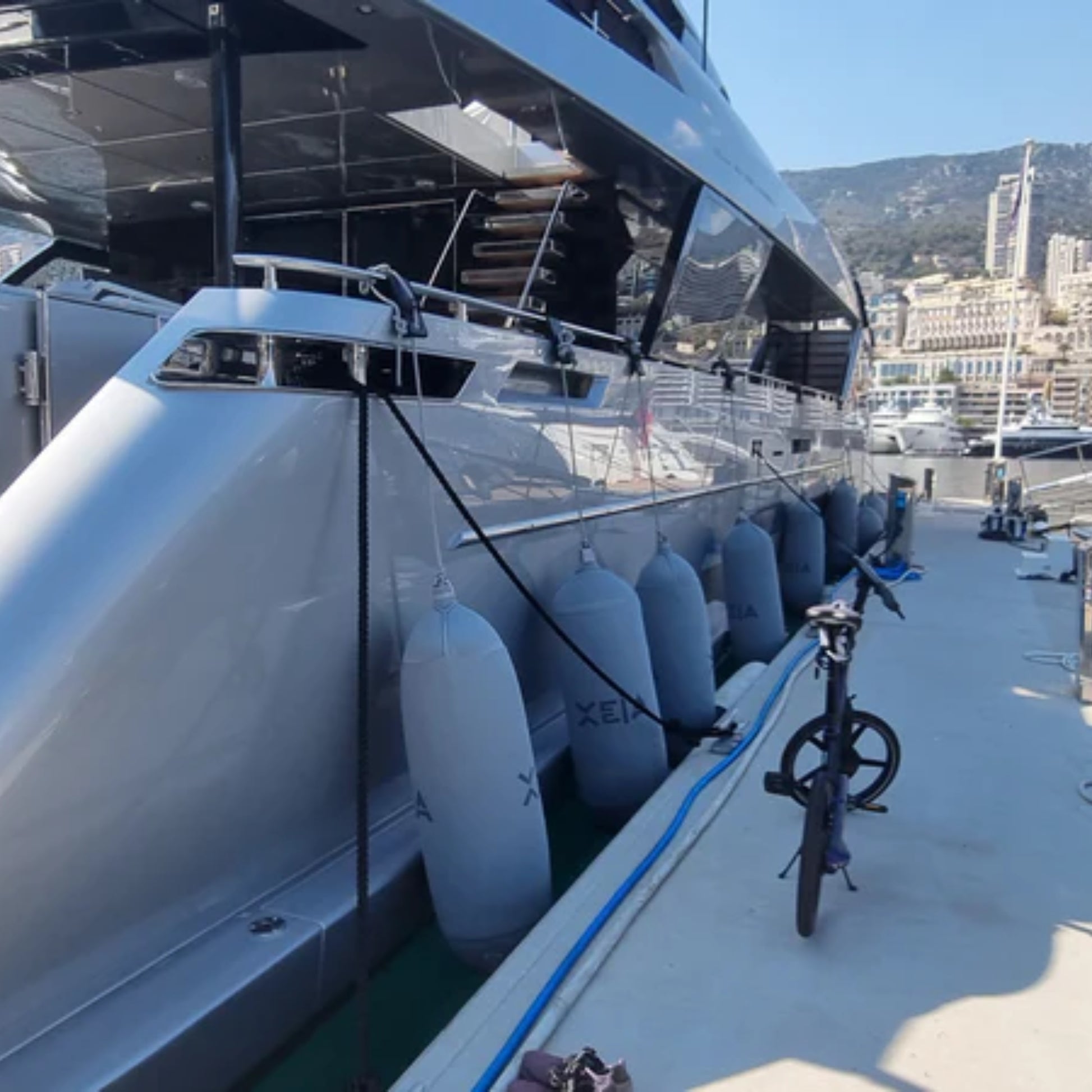 Row of Fendertex textile fenders in grey protecting a superyacht hull moored in Monaco harbour